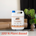 GleamSure cleaner bottle placed near a living room sofa and plant, with the text '100% Plant Based